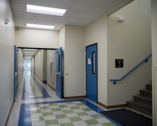hallway with double doors and a stairway