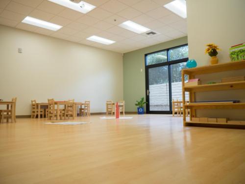 wide open room with wooden floors and furniture