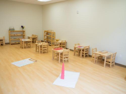 classroom with small wooden tables and chairs