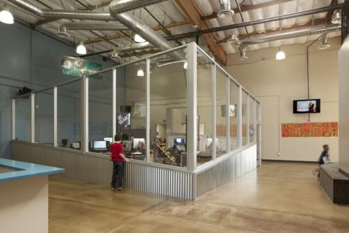 student looking through a window into a work area