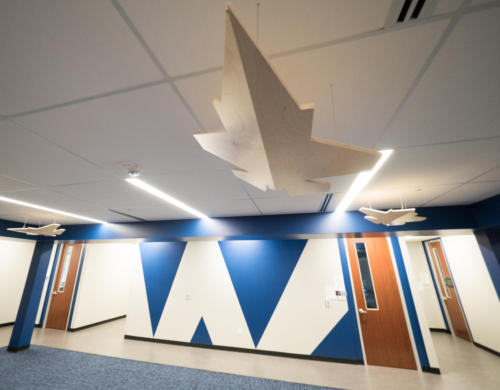Foyer area with wooden model of military aircraft hanging from ceiling