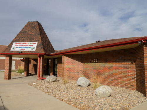 Exterior of Global Village International Littleton with an enrollment sign visible