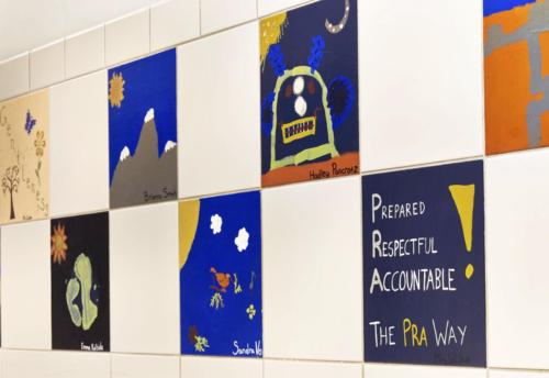 closeup of student art projects hanging in a hallway