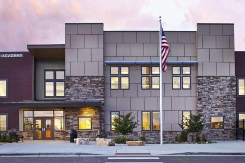 school entrance and flagpole at sunset