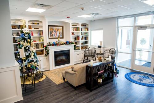 Inside the school entrance with a couch and a Christmas tree