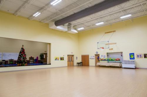 View of the school gym with a stage with a Christmas tree on it