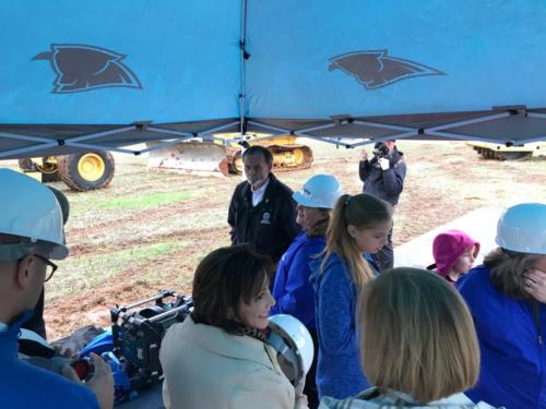 People standing under a canopy tent at the Davidson Charter Academy groundbreaking