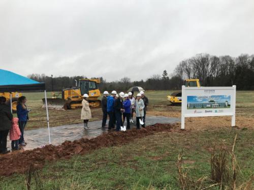 People with shovels standing near construction equipment