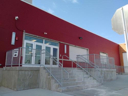 A red exterior wall with stairs leading up to an entrance