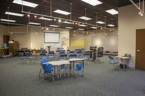 Conference room with folding chairs set up near a projector screen