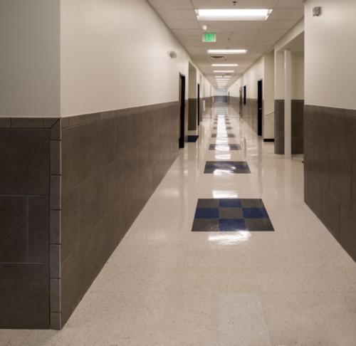 View down a long school hallway with a shiny tile floor