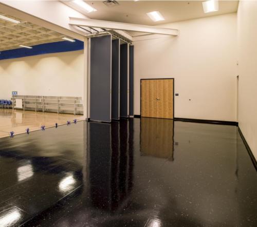 A shiny black stage just off of the school gym