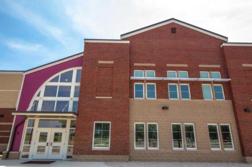 Large multi-colored brick wall near the entrance of the charter school