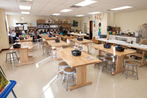 Art classroom with many long wooden tables