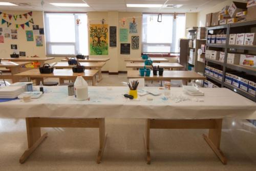Art supplies sitting on a long wooden table