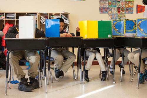 Students using folders as privacy partitions while testing