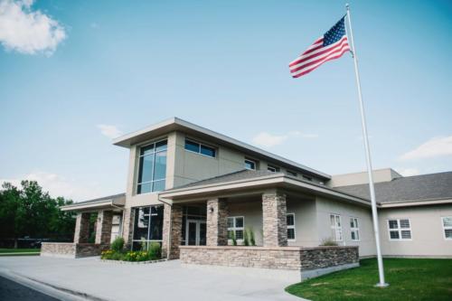 A closeup of the flagpole and school entrance